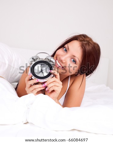 pretty brunette girl waking up and switching off the alarm clock