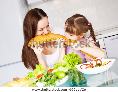 young mother and her five year old daughter  cook together on the kitchen at home