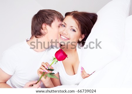 stock photo : young man kissing his beautiful girlfriend and giving her a rose