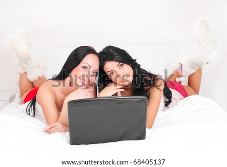 happy brunette girls with  a laptop on the bed at home