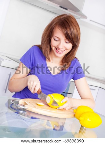 pretty young woman with lemons in the kitchen at home