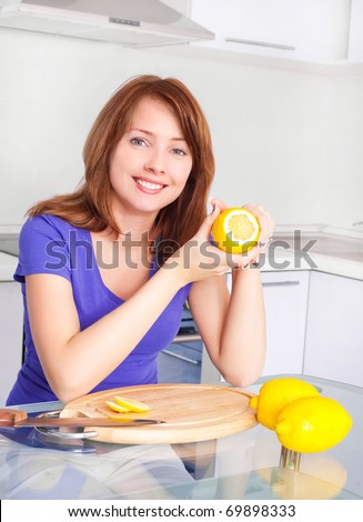 pretty young woman with lemons in the kitchen at home