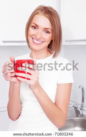 beautiful happy young woman drinking coffee at home in the morning