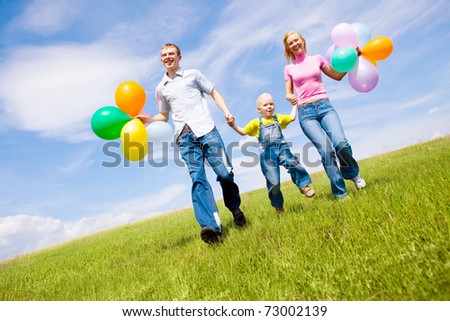 happy family with balloons outdoor on a summer day