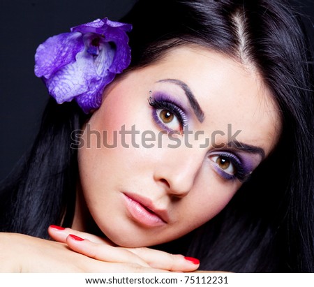 beautiful young brunette woman with  an orchid in her hair