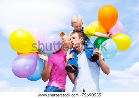happy family with balloons outdoor on a summer day