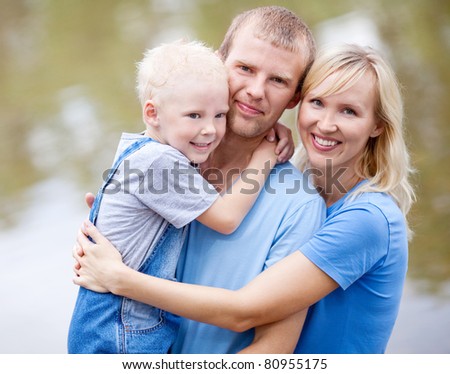 happy young family  near the lake outdoor on a summer day