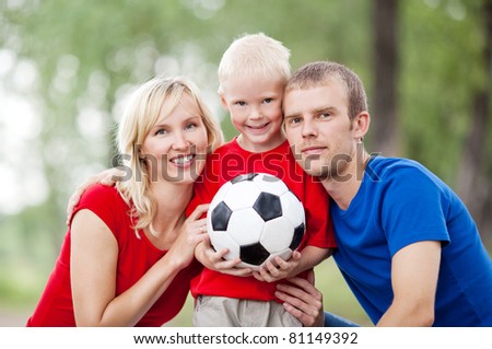 happy young family spending time outdoor on a summer day and playing ball(focus on the child)