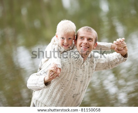 happy  family; young father and his five year old son near the lake outdoor on a summer day (focus on the man)