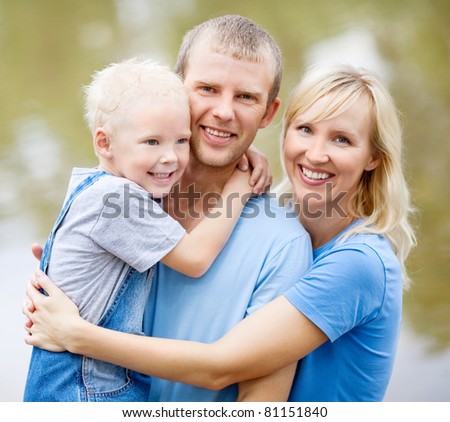 happy young family  near the lake outdoor on a summer day (focus on the child)