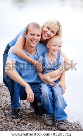 happy young family  near the river outdoor on a summer day