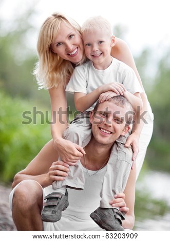 happy young family spending time outdoor on a summer day (focus on the man)