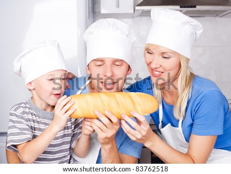 young family; father, mother and their five year old son eating bread together in the kitchen at home