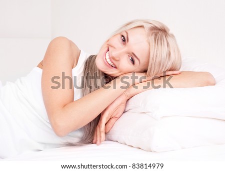 beautiful young blond woman relaxing on the bed at home