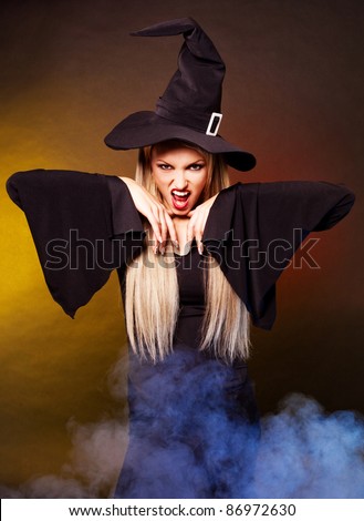 angry young blond witch with  clouds of blue smoke around her,against black background