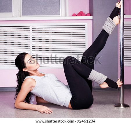 Young sexy pole dance woman, wearing sports clothes