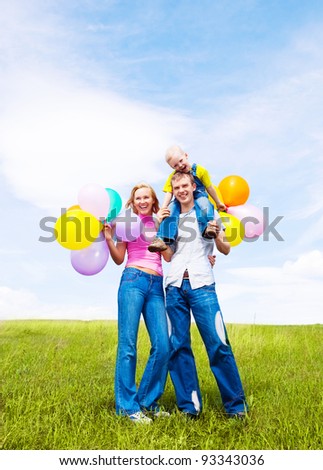happy family with balloons  outdoor on a warm summer day