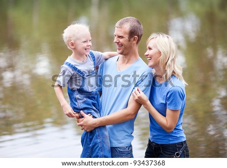 happy laughing family  having a walk near the lake outdoor on a summer day