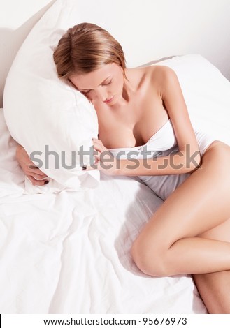 sexy young woman sleeping in a big bed at home (top view)