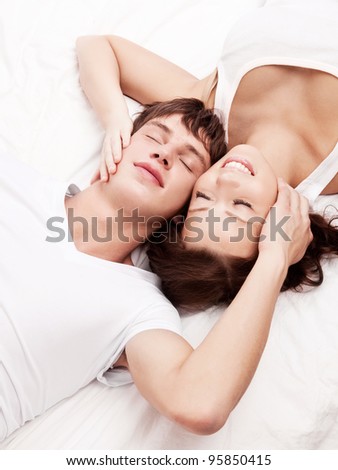 happy young beautiful couple in bed at home, top view