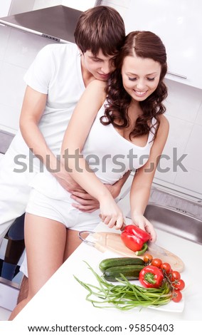 happy young loving couple cooking together in the kitchen at home