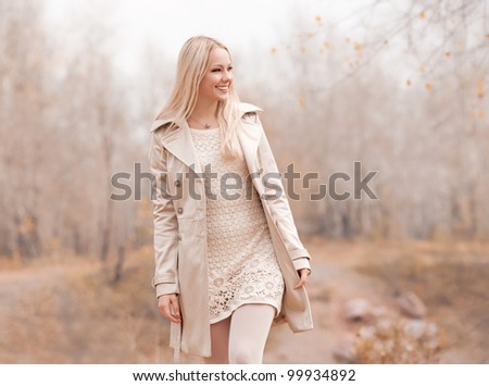 beautiful young blond woman spending time in the autumn park