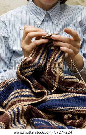hands of a woman knitting with cotton and metal knitting needle