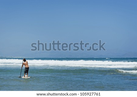 Stand Up Paddle Surf man going to waves to practice this sport