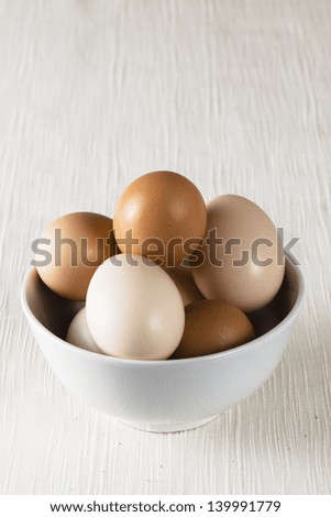 Different kind of eggs in a white bowl