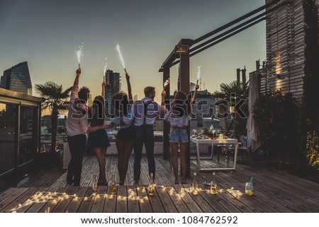 Multi-ethnic group of friends having party on  rooftop - Happy people bonding and having fun