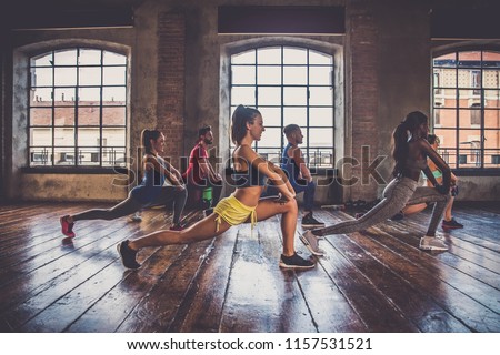 Multi-ethnic group of people training in a gym - Personal  trainer and sportive persons  in a fitness class