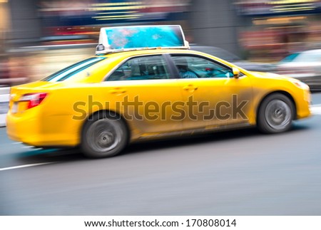 NEW YORK - DECEMBER 22, 2013: yellow taxi speeding in Times Square,New York. Yellow cars serve as taxis in NYC and are easy to spot among other vehicles because of their color.