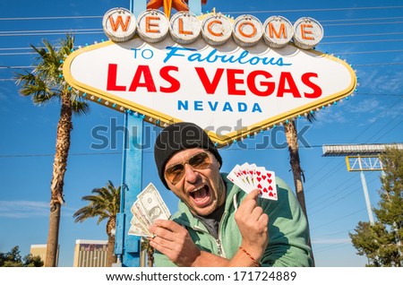 Enthusiastic man with dollars and royal flush in front of Las Vegas sign