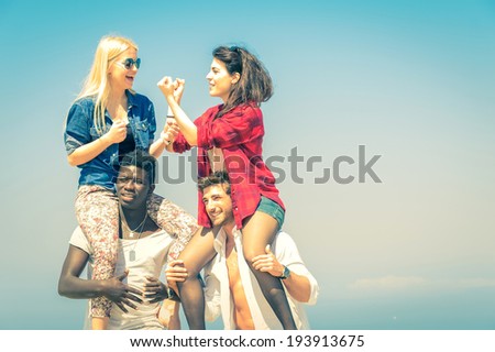 Happy couples on beach having fun - piggyback ride outdoor