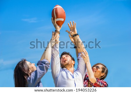Two young women trying to catch an american football ball