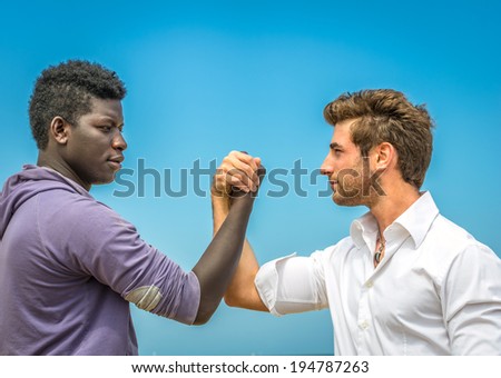 Afroamerican and caucasian man  shaking hands - peace,teamwork,collaboration,diversity concept
