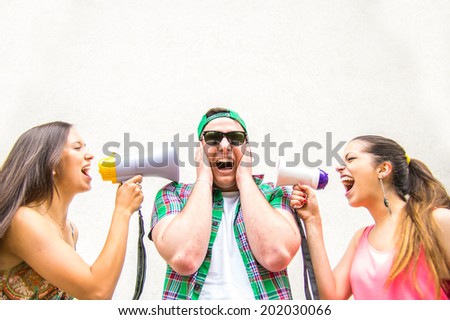 Funny image of two women screaming with megaphones in to  man\'s ears - shopping,funny,disagreement concept