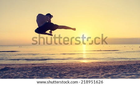 flying kick on the beach at sunrise