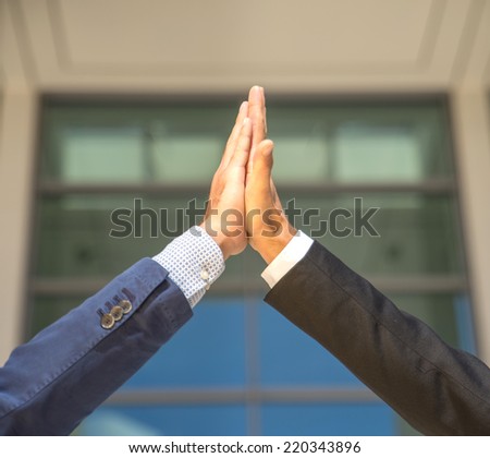 Two business men giving a high five to each other.High five concept for success, teamwork, congratulating and celebration