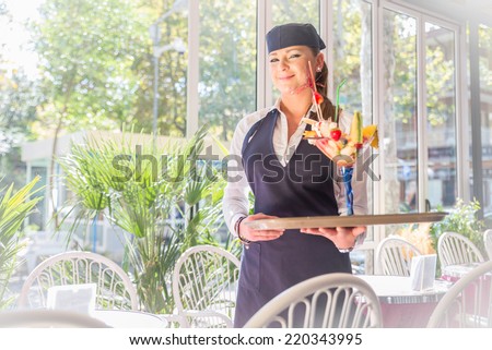 Pretty waitress serving a cup of ice cream in a bar cafe