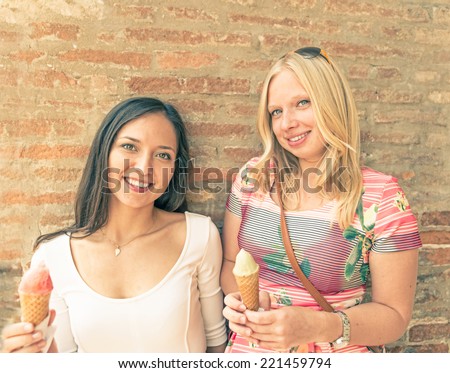portrait with two smiling women eating ice cream