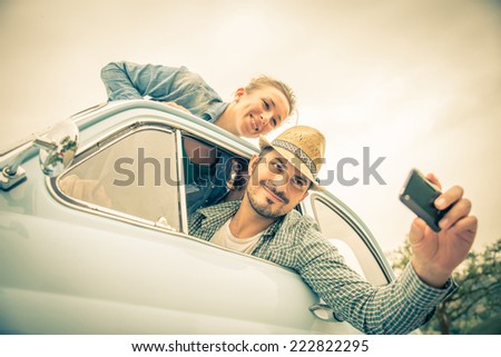 Happy couple on vintage car - Two friends photographing on a road trip - Concepts of couple,travel and fun