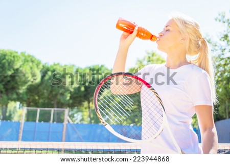 thirsty athlete. tennis player drinking power drink