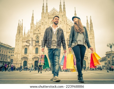 Couple buying during a sale - Attractive man and woman holding shopping bags and having fun - Autumn and winter mood