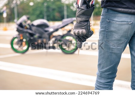 biker with motorcycle key. concept about transportation and motorbikes.