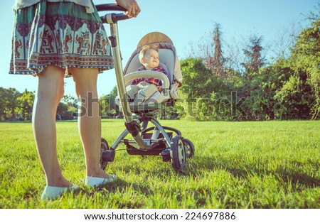 mom with stroller. walking in the park. Concept about parents and kids