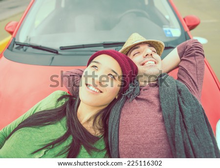 happy couple lying on the car hood. concept of carefree and relaxation