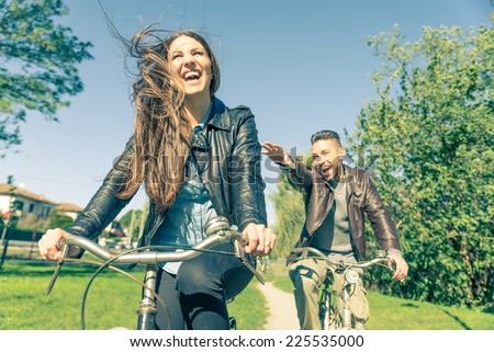 Couple riding on bicycles  and having fun - Tourists driving around the city - Two friends riding on bikes in the countryside