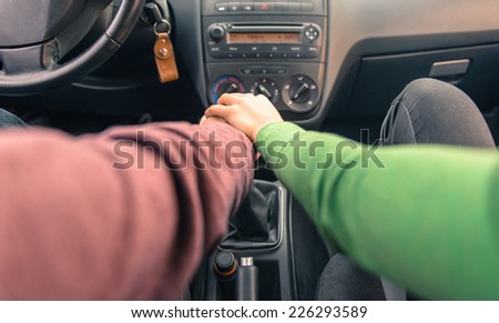 couple holding hands in the car. concept about love and transportation