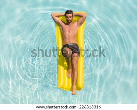 man relaxing on the air bed in the swimming pool. concept about vacation and free time